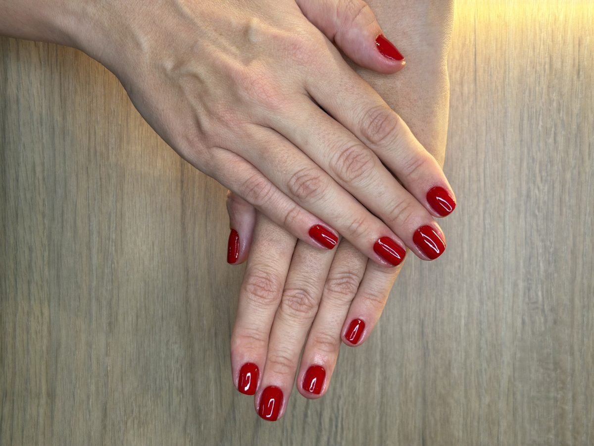 Resultado de manicure tradicional com esmalte vermelho na Sterby